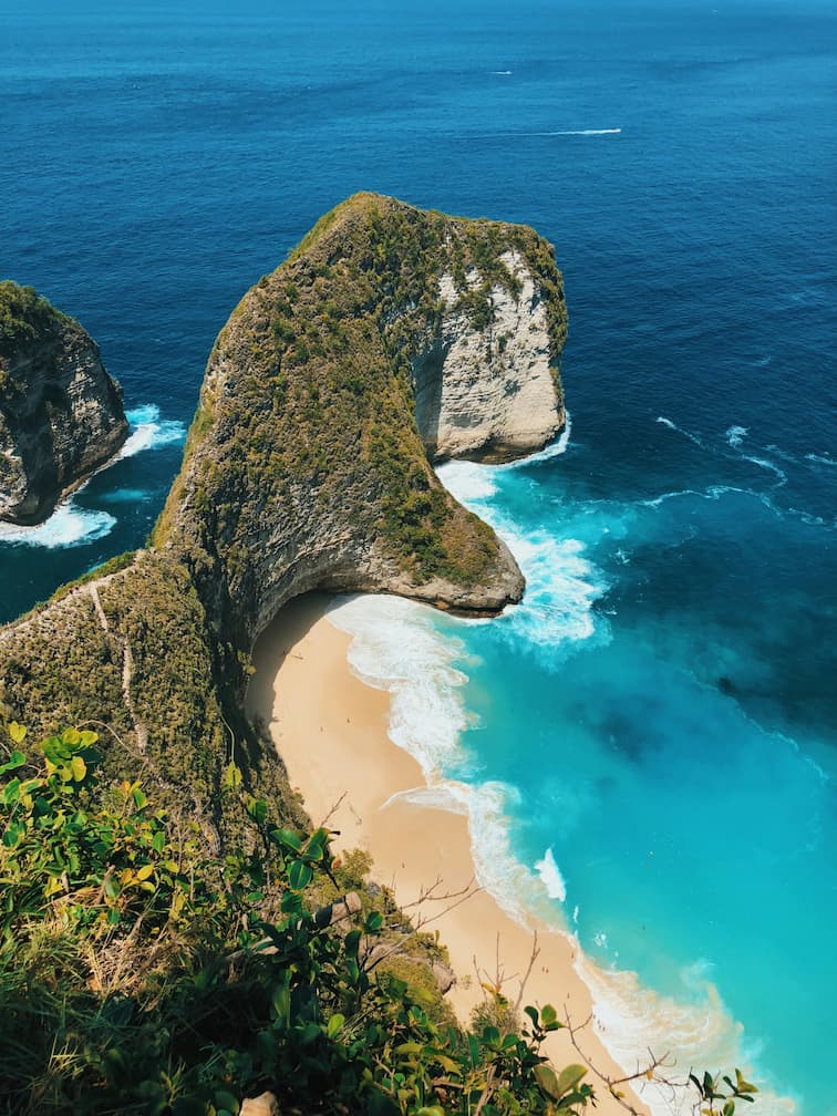 Un risco que se introduce en el mar con una pequeña cala en Bali